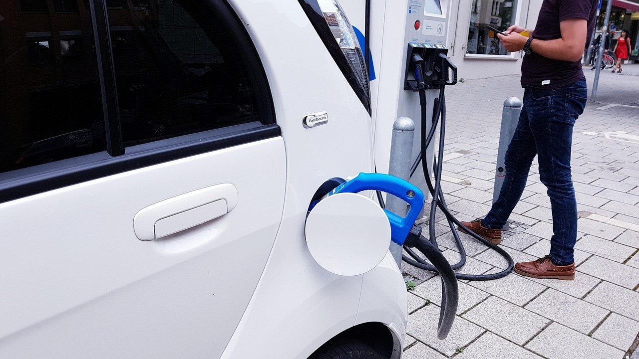 Man charging his electric car at a charging station