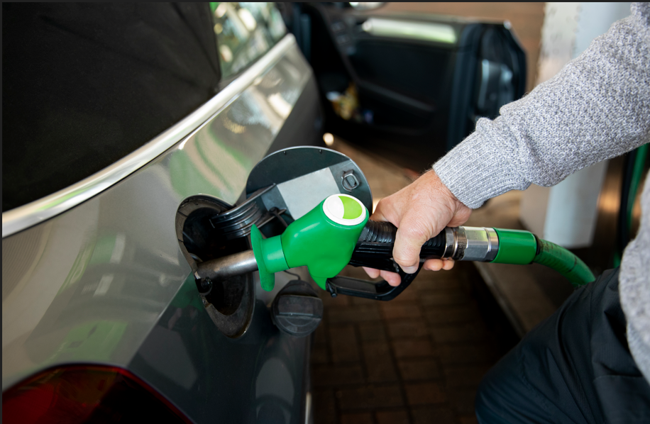 Man filling fuel in car, holding gas pump