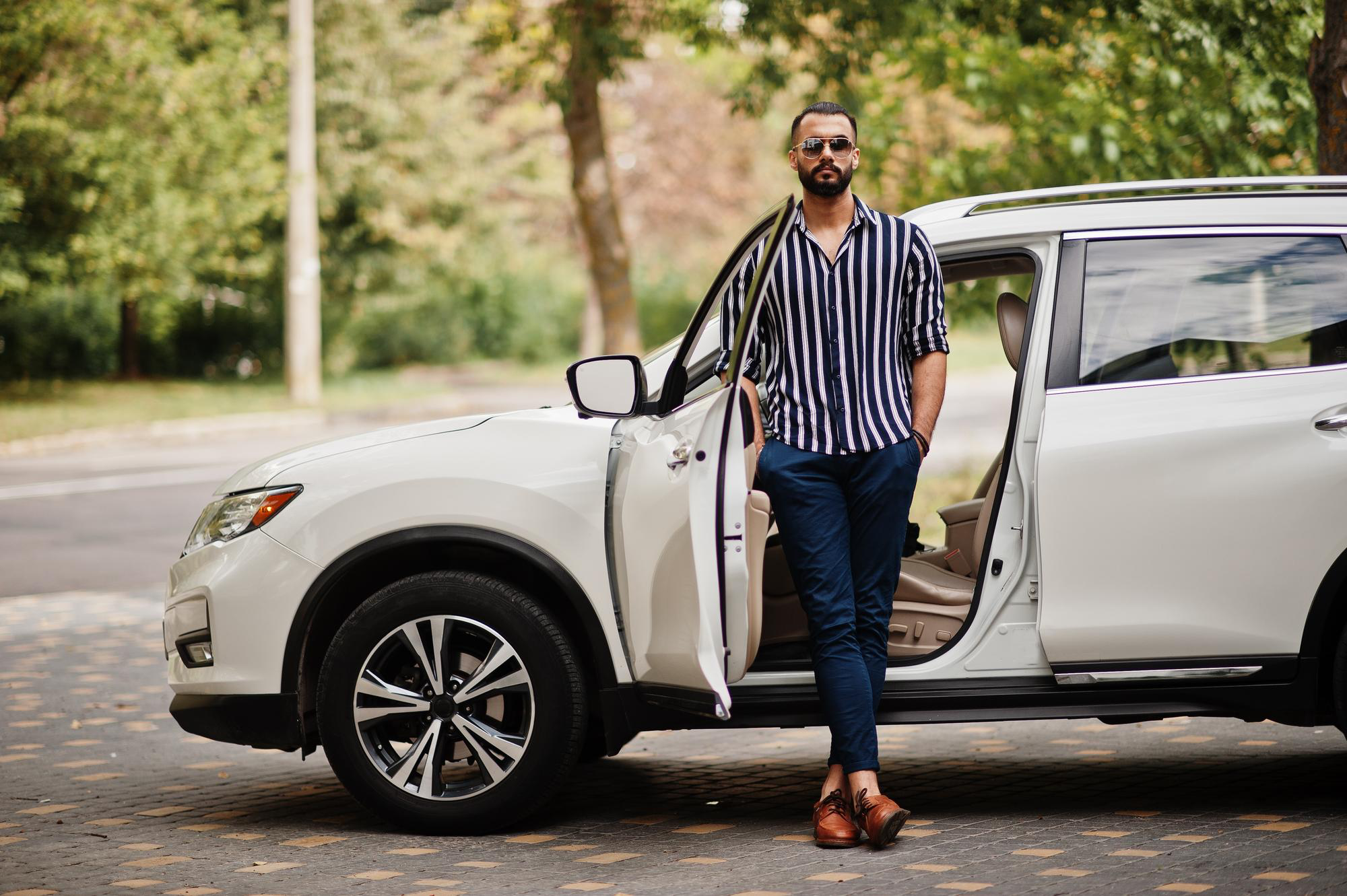 A person posing beside their car door.