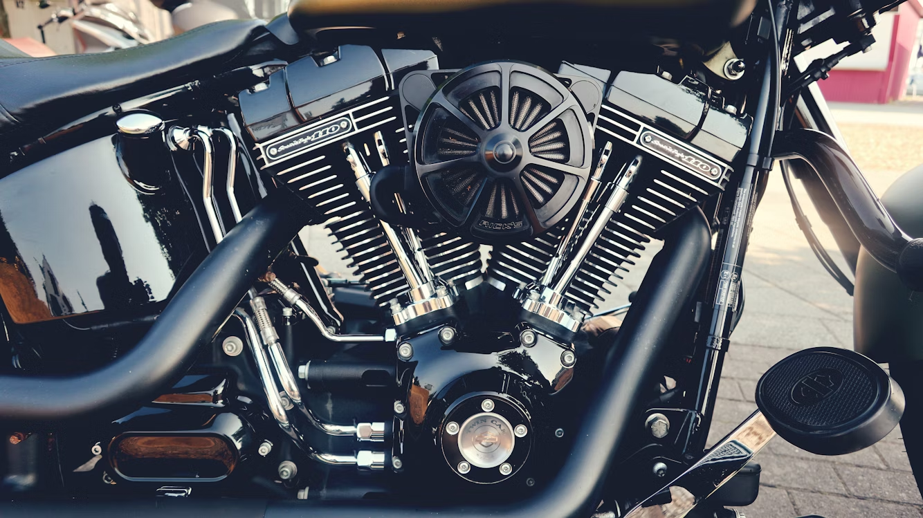 Close-up view of a motorcycle engine, showing detailed chrome and black components, including the air filter, exhaust pipes, and engine