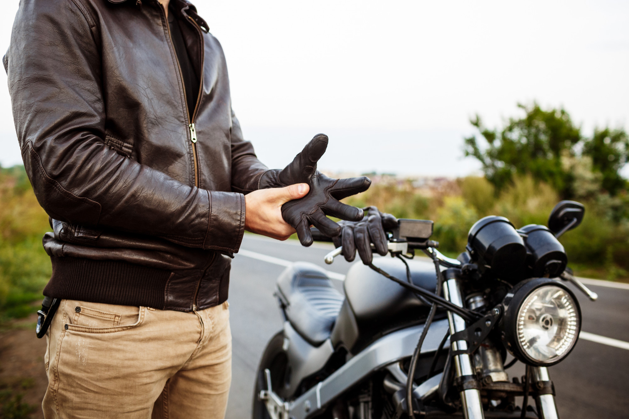 A biker standing next to their bike and getting ready for a ride.