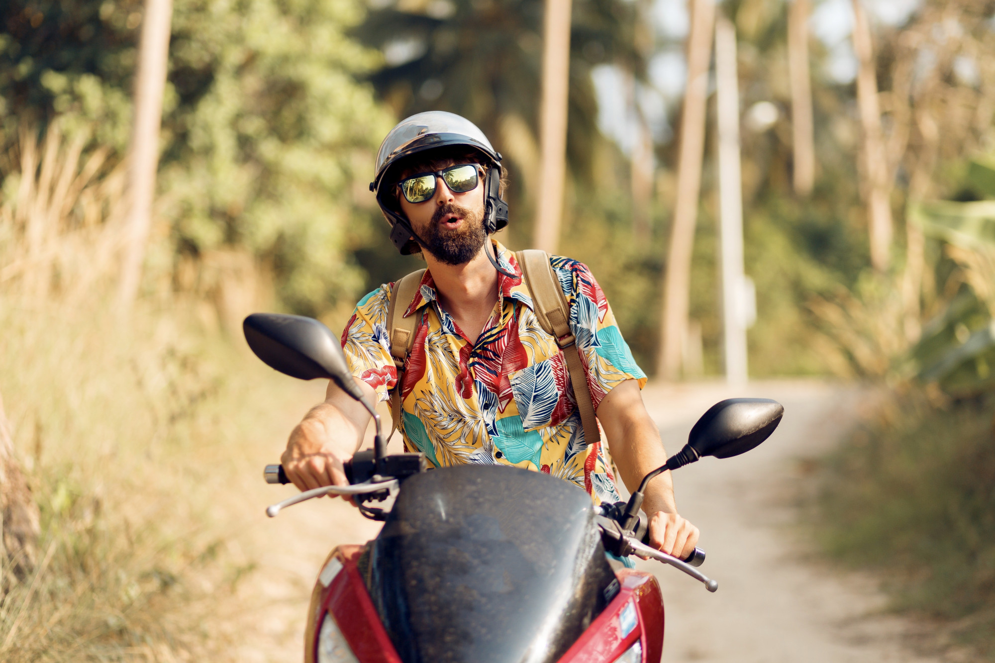 A young person riding their bike through a winding lane surrounded by trees.