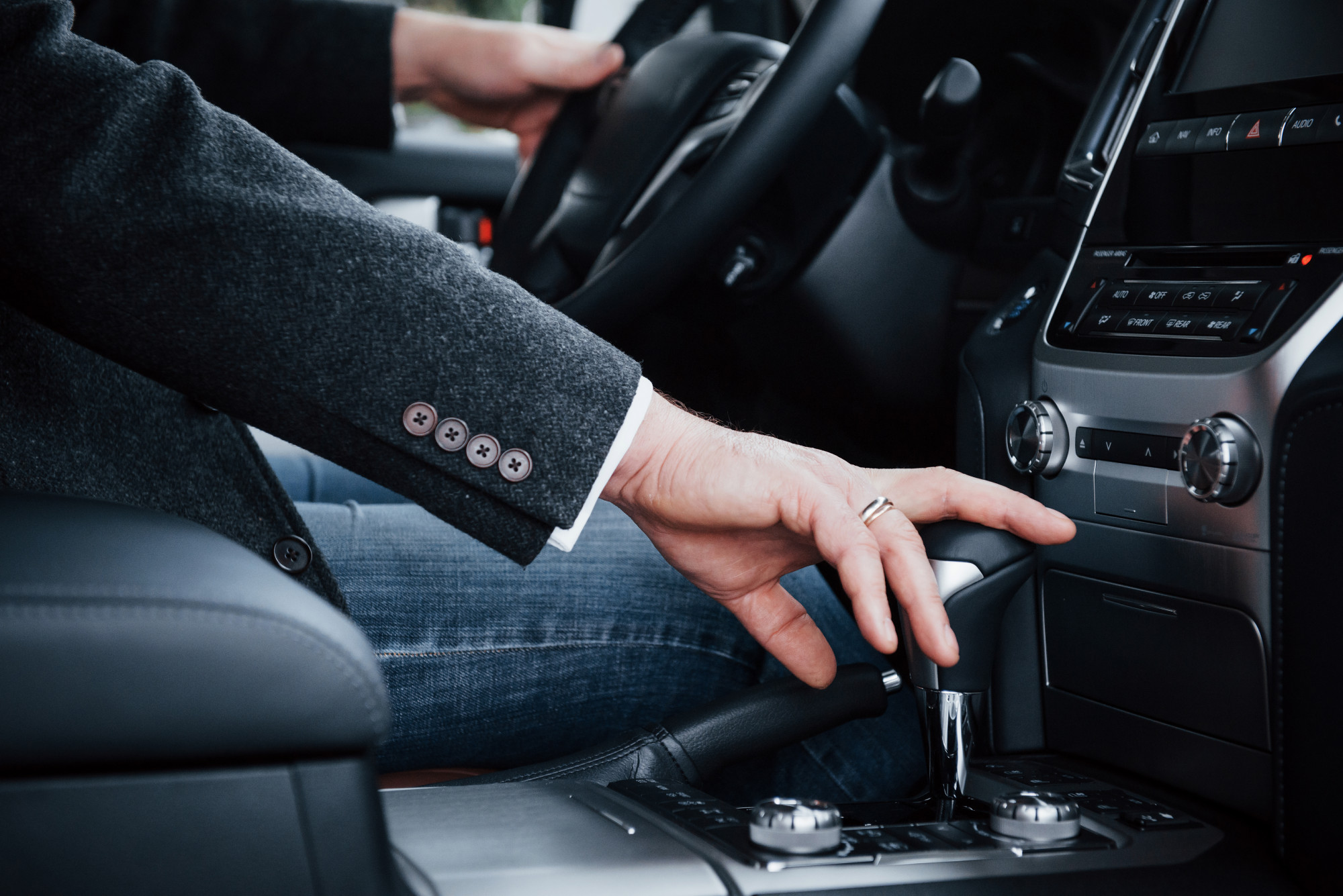 A man changing the gears of the car.
