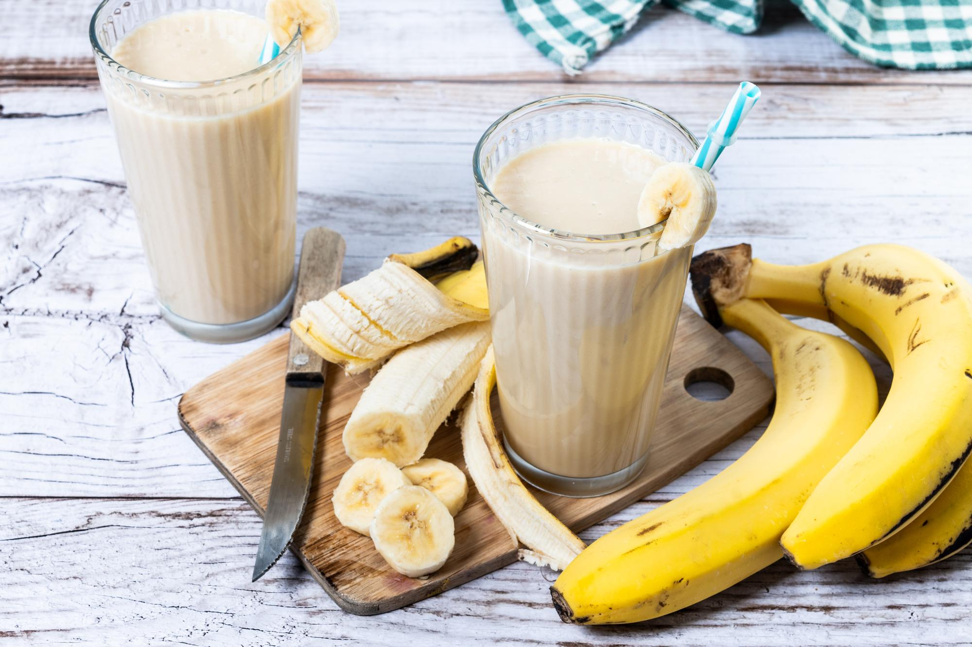Fresh glass of banana shake placed on a table. 