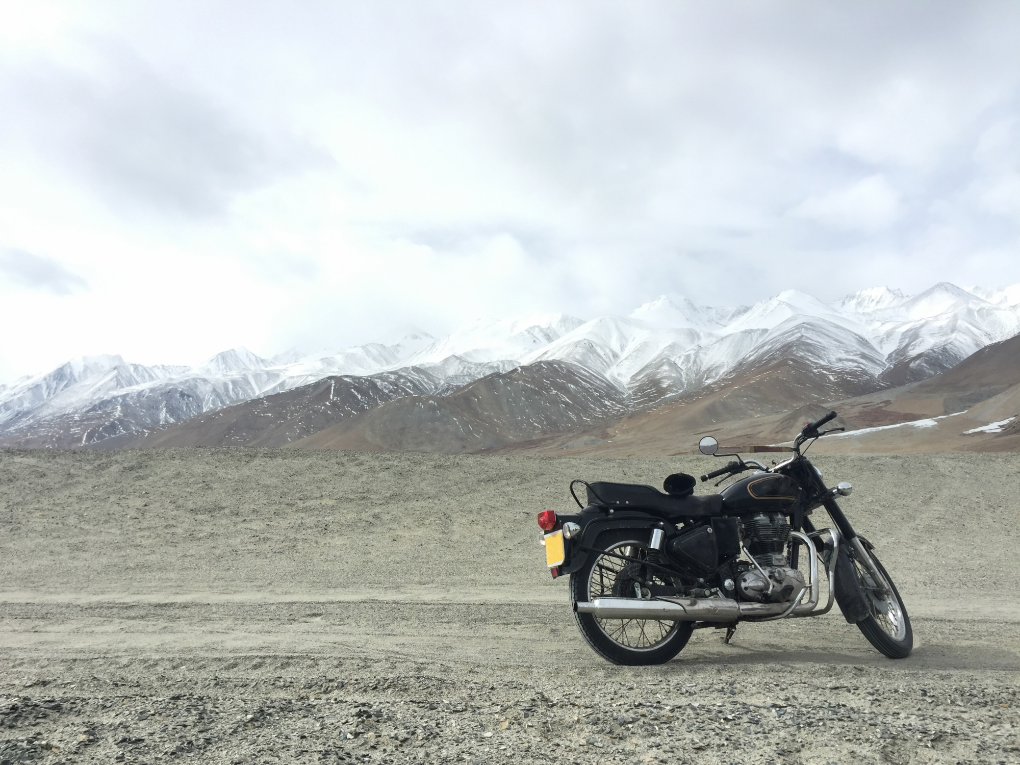 A bike parked against a mountain backdrop.
