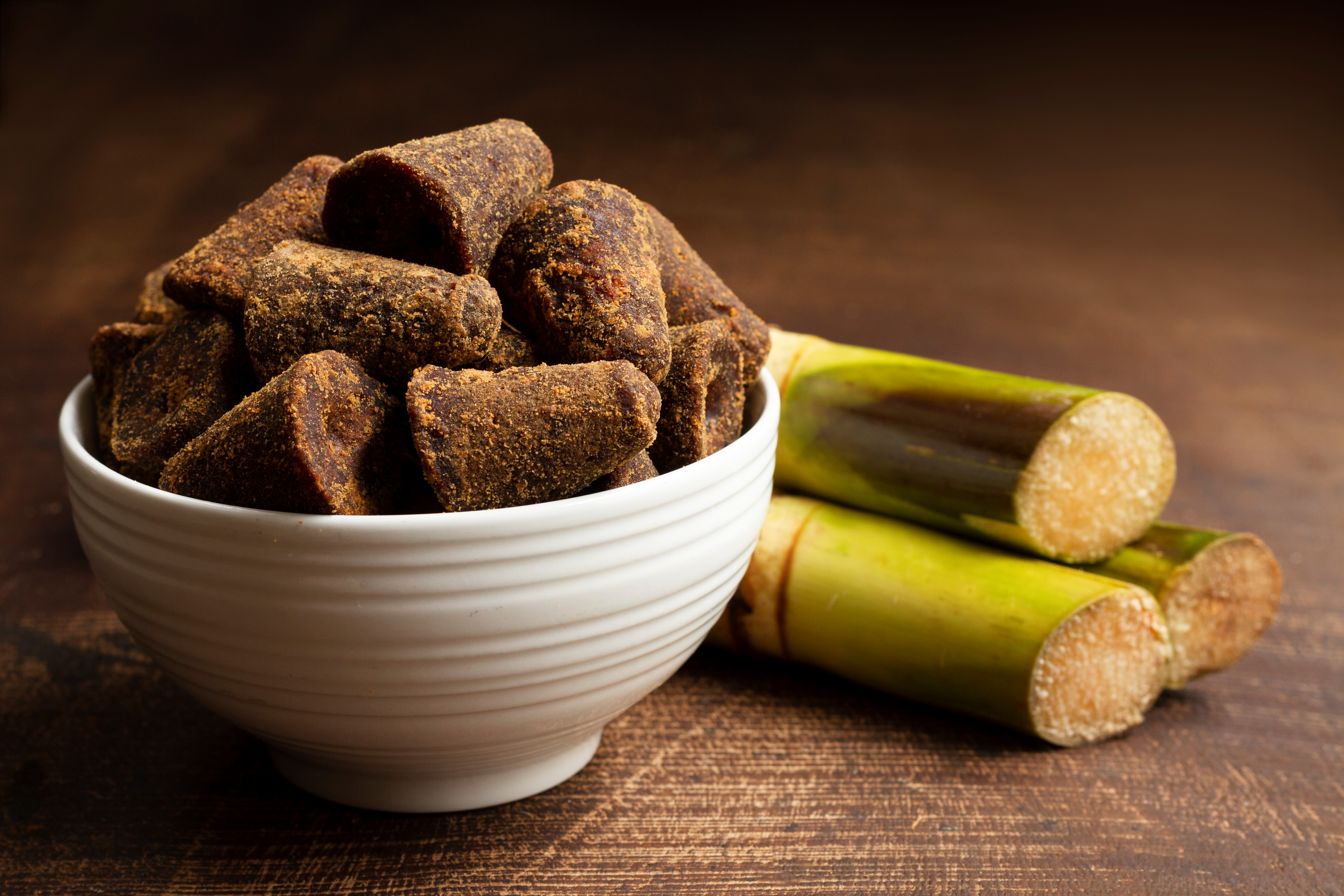 Jaggery and sugarcane on a table.