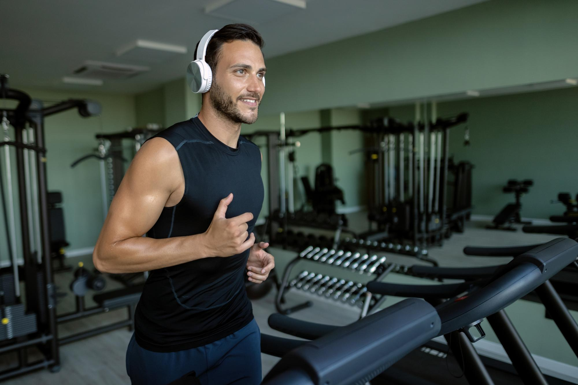 Man running on a treadmill in a gym.