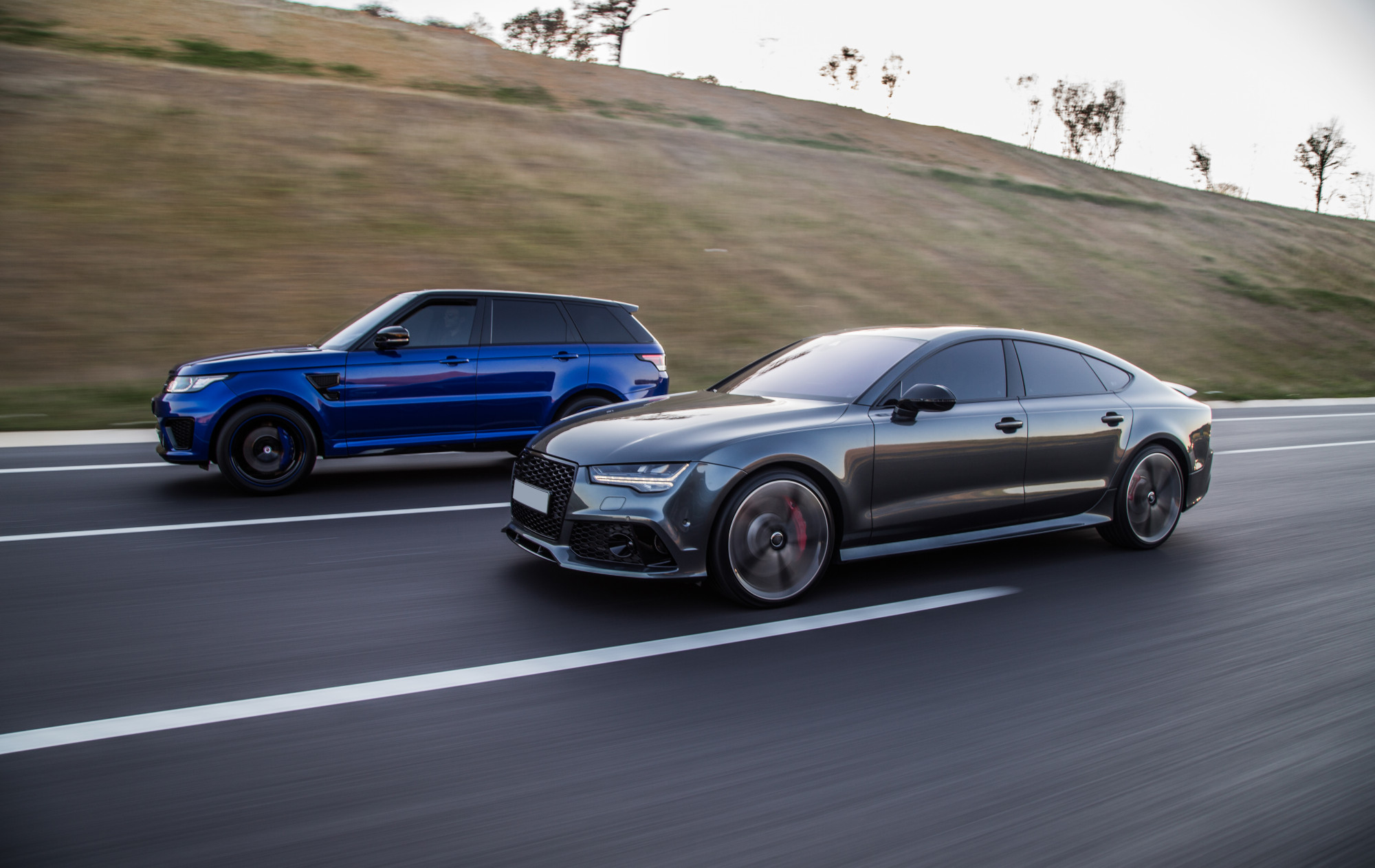 A sedan and an SUV on the road.