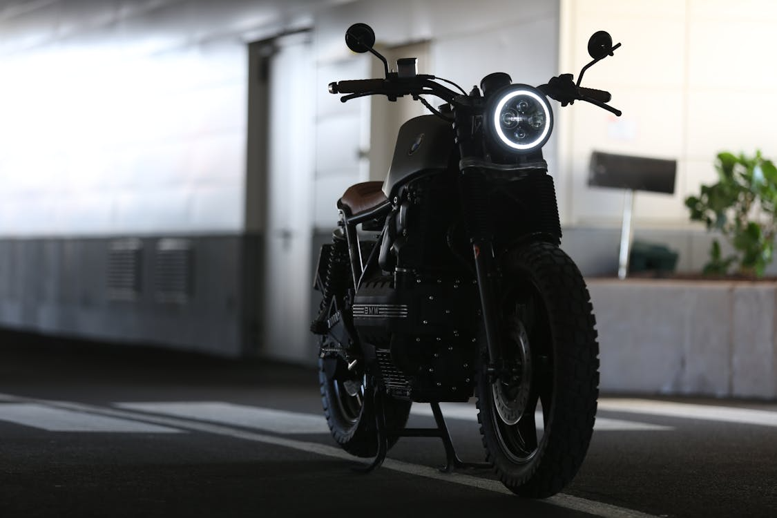 A black motorcycle parked indoors under soft lighting.