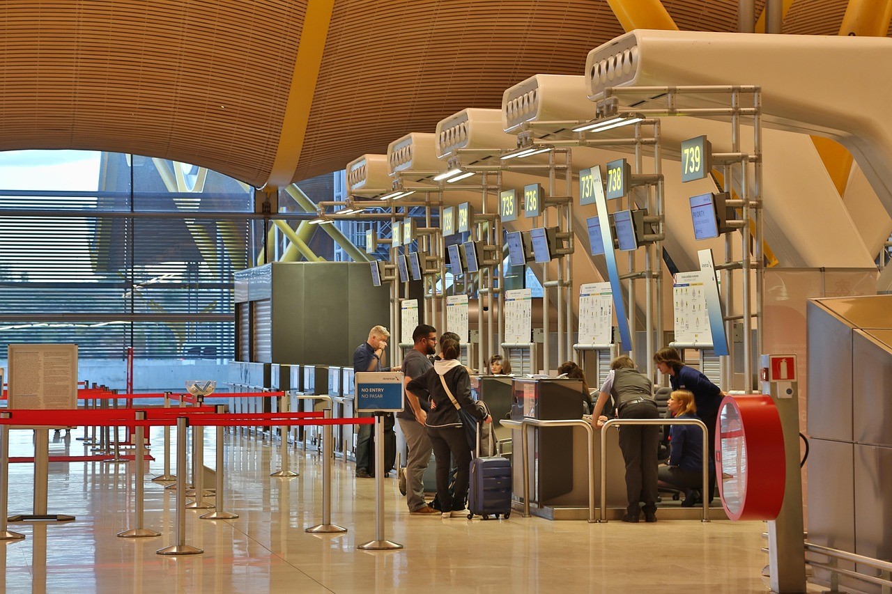 Passengers at an airline counter in an airport.